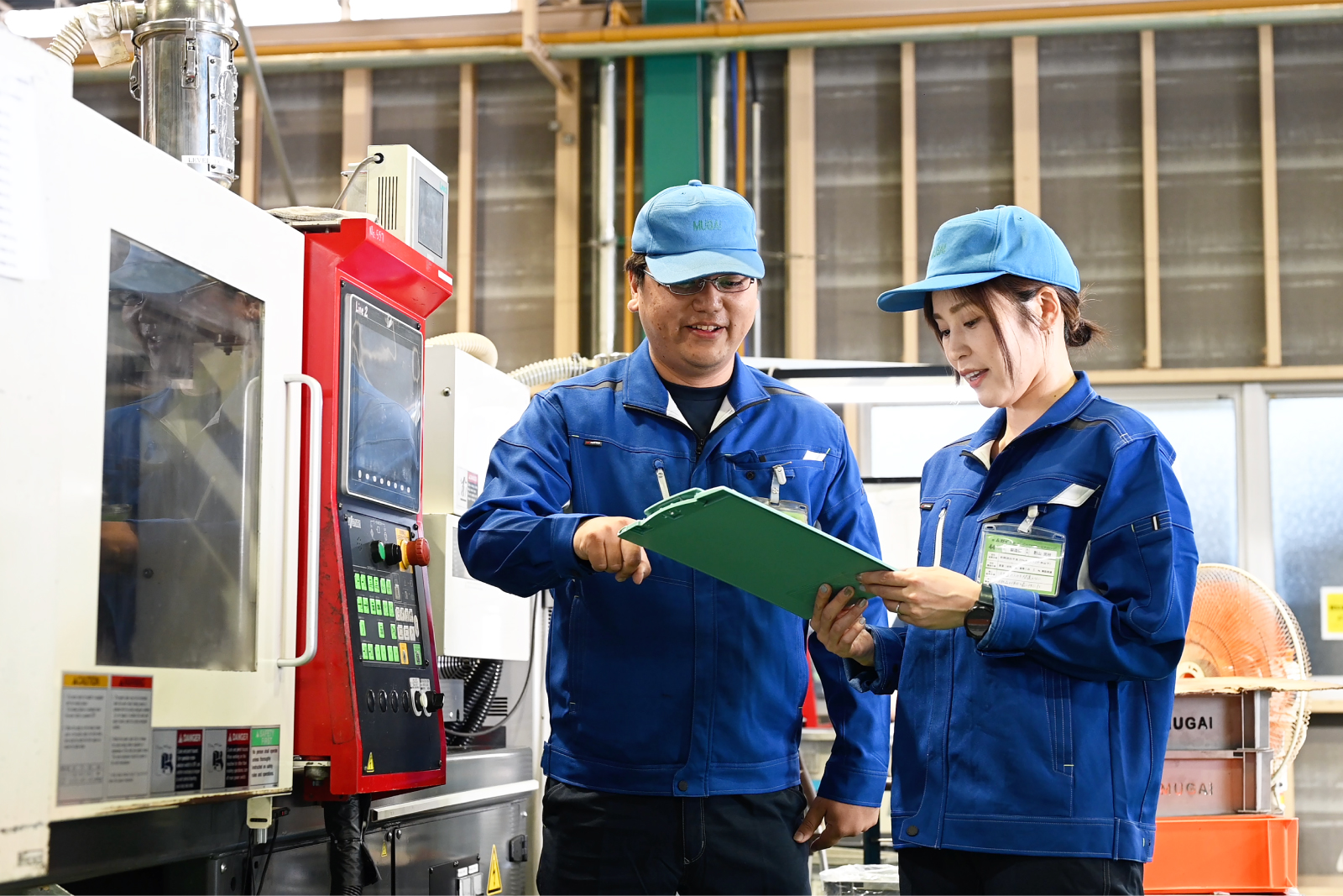 青色の制服で精密加工を行う様子